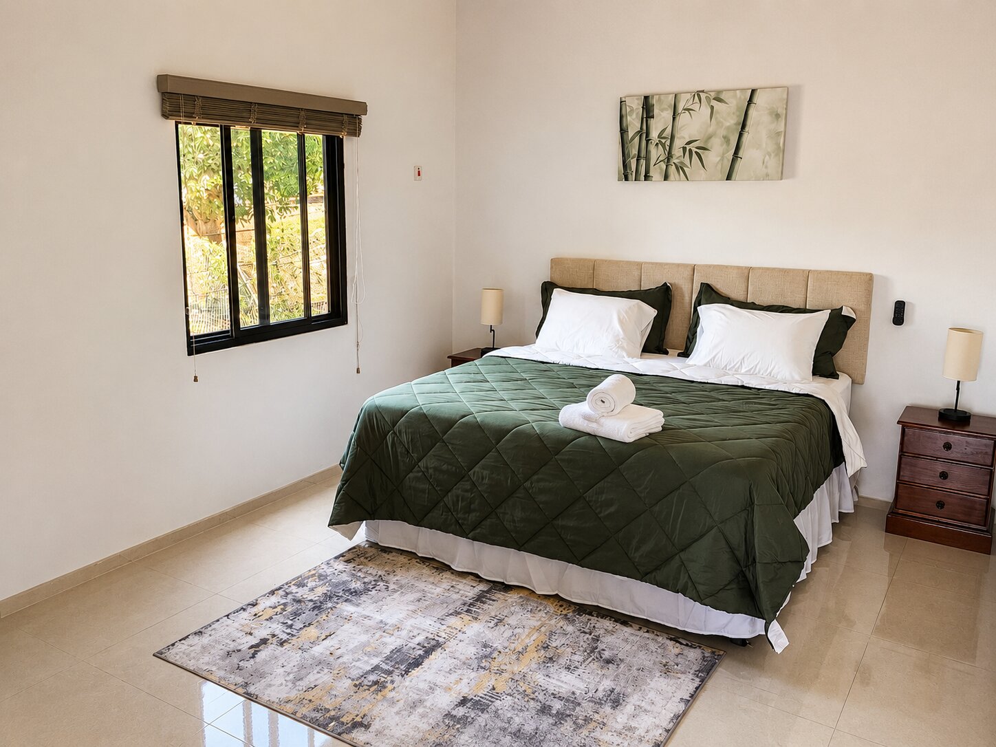 The Bamboo bedroom, with green bedding, garden-view window and bamboo artwork